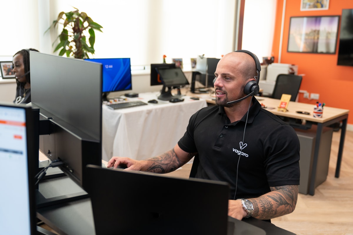 A travel advisor at a desk wearing a headset — the human who closes the booking after Mark hands over a qualified lead